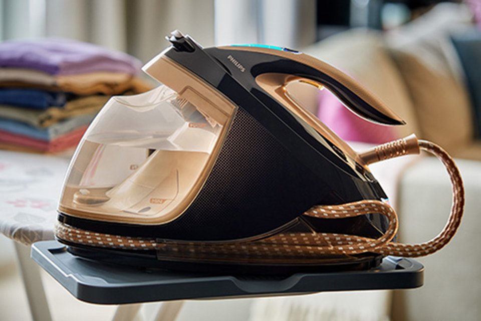 A black steam generator Philips iron on a cloth.